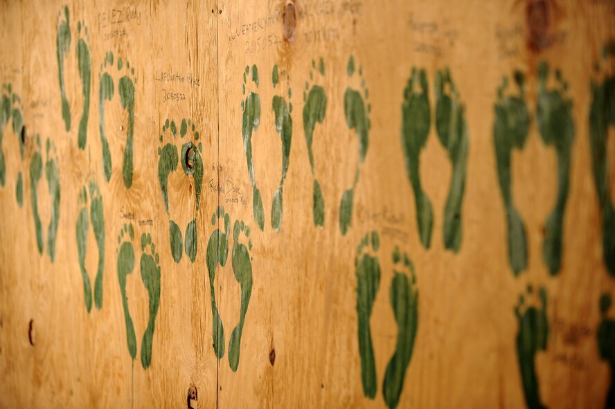 U.S. Air Force Airmen of the 64th Expeditionary Helicopter Maintenance Unit leave green footprints on the walls of a building in Iraq, Sept. 15, 2015. The “Jolly Green” footprints are a tradition here to signify an Airman’s first deployment and leave a lasting legacy of their support to Operation Inherent Resolve, which has destroyed or damaged more than 10,000 targets as of Aug. 7, 2015. (U.S. Air Force photo/Tech. Sgt. Brittany E. Jones) 