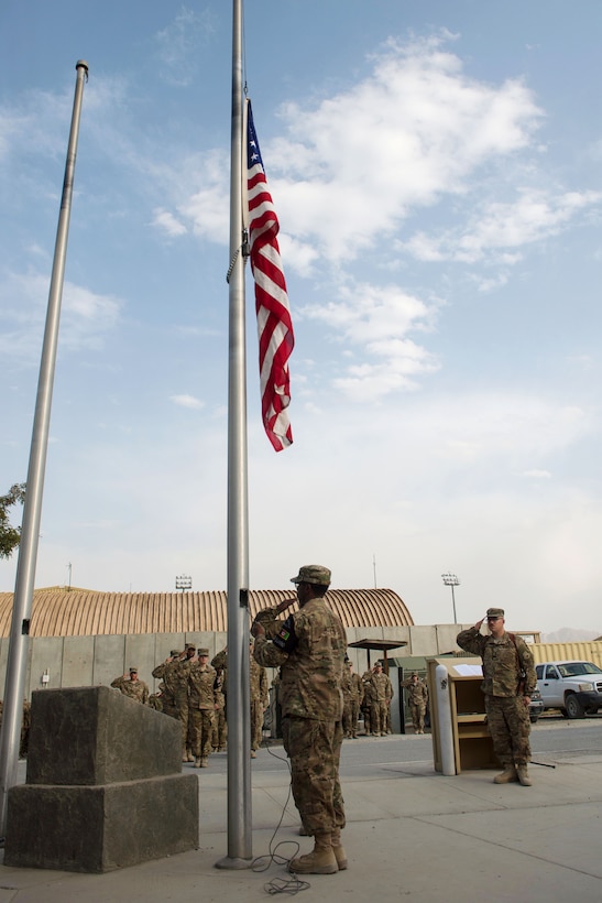 U.S. airmen lower the U.S. Flag during the POW/MIA Remembrance and Retreat ceremony on Bagram Airfield, Afghanistan, Sept. 17, 2015. The airmen are members of the Bagram Airfield Honor Guard. U.S. Air Force photo by Tech. Sgt. Joseph Swafford