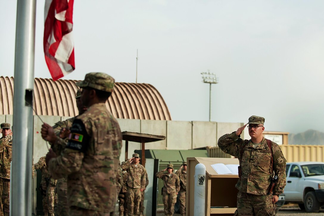U.S. Air Force 1st Lt. Brendan Maestas salutes as airmen lower the U.S. Flag during the POW/MIA Remembrance and Retreat ceremony on Bagram Airfield, Afghanistan, Sept. 17, 2015. Maestas is assigned to the 455th Expeditionary Civil Engineer Squadron. U.S. Air Force photo by Tech. Sgt. Joseph Swafford