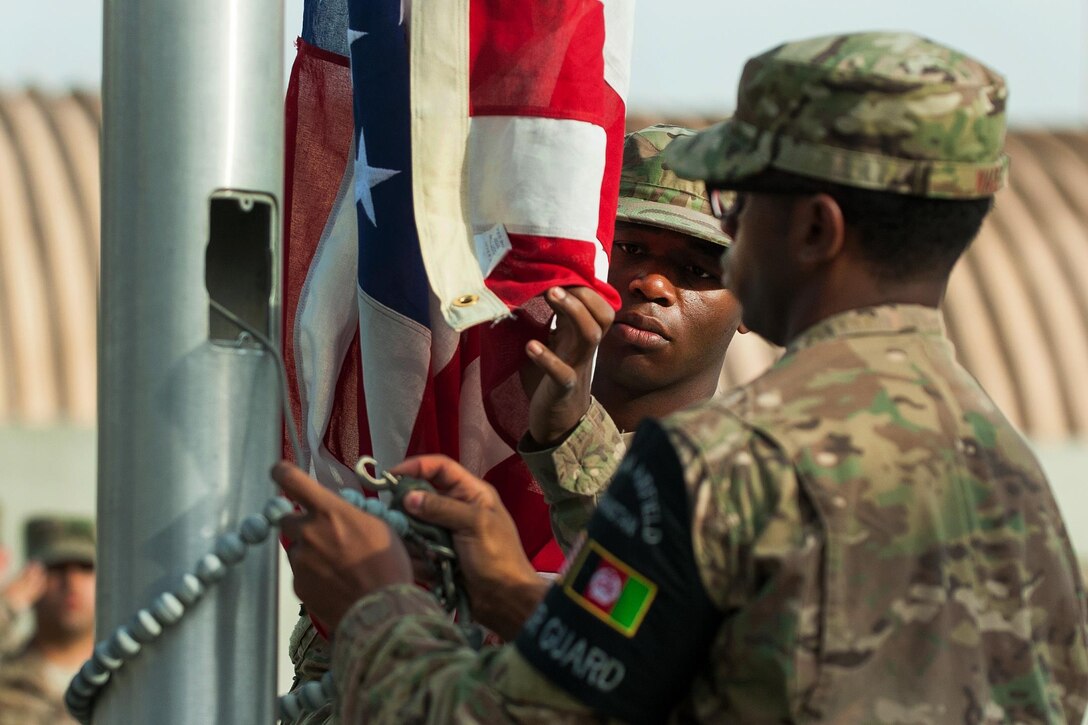 U.S. airmen lower the U.S. Flag during the POW/MIA Remembrance and Retreat ceremony on Bagram Airfield, Afghanistan, Sept. 17, 2015. U.S. Air Force photo by Tech. Sgt. Joseph Swafford