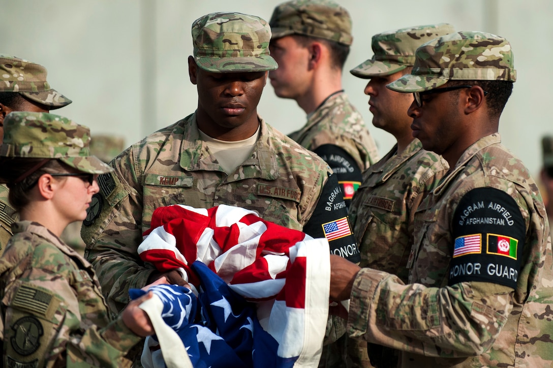 U.S. airmen fold the U.S. Flag during the POW/MIA Remembrance and Retreat ceremony on Bagram Airfield, Afghanistan, Sept. 17, 2015. U.S. Air Force photo by Tech. Sgt. Joseph Swafford