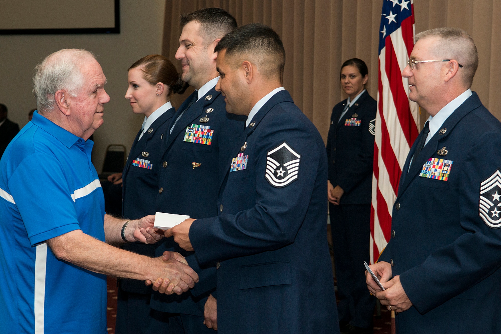 Mr. Don Reed gives a $50 gift card to U.S. Air Force Master Sgt. Curtis Downey during a 307th Bomb Wing commander's call on Sept. 13, 2015, Barksdale Air Force Base, La. Members of local businessess in the Shreveport and Bossier City area attend awards ceremonies to show their appreciation and give thanks to distinguished Airmen of the U.S. Air Force Reserve Command. (U.S. Air Force photo by Master Sgt. Greg Steele/Released)