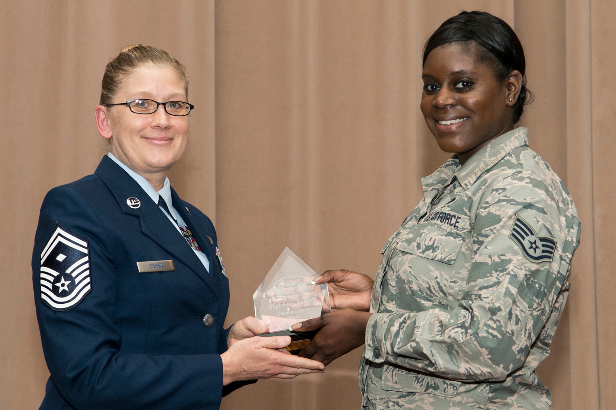 U.S. Air Force Senior Master Sgt. Shelly Cohen presents the Diamond Sharp Award to Staff Sgt. Amy Russell during the 307th Bomb Wing's commander's call, Sept. 13, 2015, Barksdale Air Force Base, La. Russell is assigned to the 307th Maintenance Squadron and was selected for the award during the 2nd quarter of 2015. (U.S. Air Force photo by Master Sgt. Greg Steele/Released)