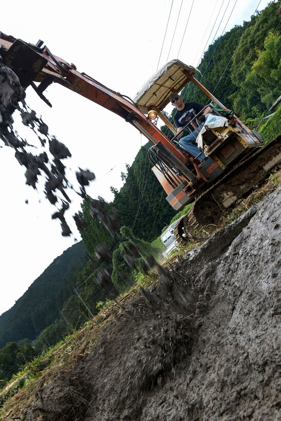 U.S. Air Force Tech. Sgt. Marshall Johnston drops mud on the side of an irrigation creek at Kanuma City, Tochigi Prefecture, Japan, Sept. 15, 2015. Johnston is a structures craftsman assigned to the 374th Civil Engineer Squadron. Johnston used mud taken from a clogged irrigation drain to fix an eroded creek wall that was leaking into a farmer's field. U.S. Air Force photo by Staff Sgt. Cody H. Ramirez 

