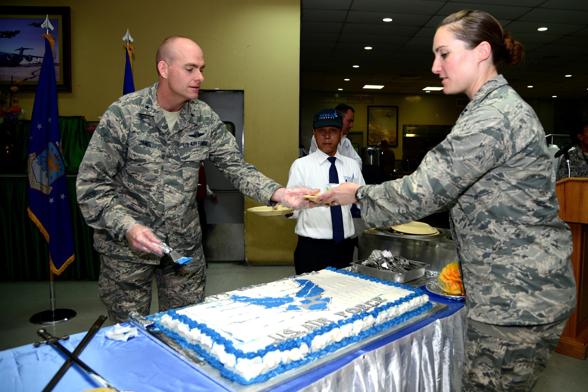 Brig. Gen. Darren James, 379th Air Expeditionary Wing commander, hands a piece of ceremonial cake to Capt. Christina MacDonald, 379th Expeditionary Forces Support Squadron community services flight commander, after cake cutting ceremony ends Sept. 18, 2015, at Al Udeid Air Base, Qatar. The cake cutting ceremony is traditionally performed by the oldest and youngest Airman. This year marks 68 years of military superiority through air power. (U.S. Air Force photo by Tech. Sgt. Rasheen Douglas)