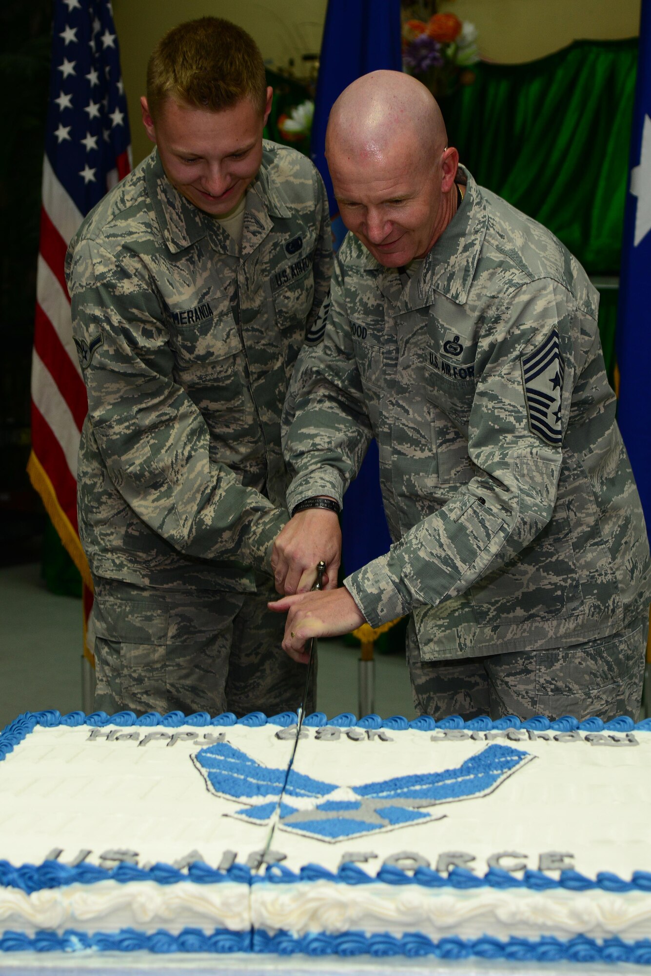 Airman Caden Meranda, 379th Expeditionary Logisitics Squadron fuels distribution officer, and Chief Master Sgt. Thomas Good, 379th Air Expeditionary Wing command chief, cut the ceremonial cake at the Independence Dining Facility, during the cake cutting ceremony Sept. 18, 2015, at Al Udeid Air Base, Qatar. The cake cutting ceremony is traditionally performed by the oldest and youngest Airman. This year marks 68 years of military superiority through air power. (U.S. Air Force photo by Tech. Sgt. Rasheen Douglas)