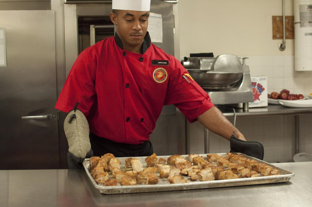 Sgt. Nicholas Graham, quality assurance evaluators for Base Food Service, prepares pork belly during the Chef of the Quarter Competition at the Bruce Chowhall, Sept. 10. The team of John Selick IV came in second place with a Hungarian inspired dish.