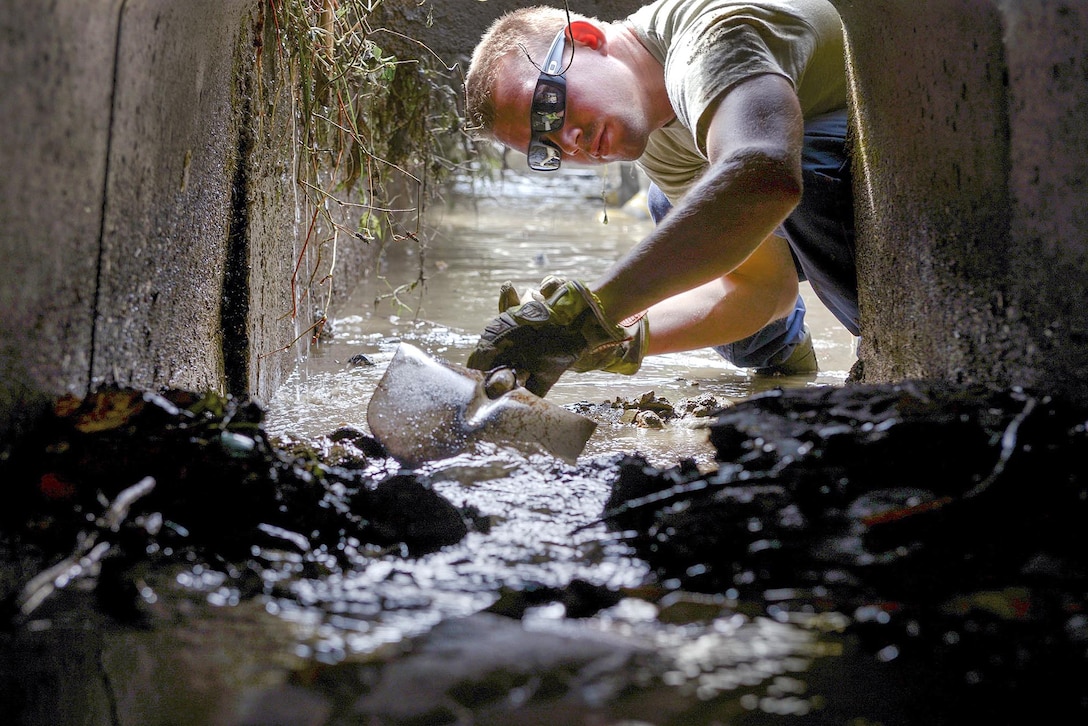 U.S. Air Force Airman 1st Class Thomas Smith shovels mud from an irrigation system at Kanuma City, Tochigi, Japan, Sept. 15, 2015. Smith is assigned to the 374th Civil Engineer Squadron. Other members of a large volunteer force from Yokota Air Base ventured to Tochigi to assist the locals with mud removal, sand bagging and fixing what was broken during a recent flood and landslide. U.S. Air Force photo by Staff Sgt. Cody H. Ramirez