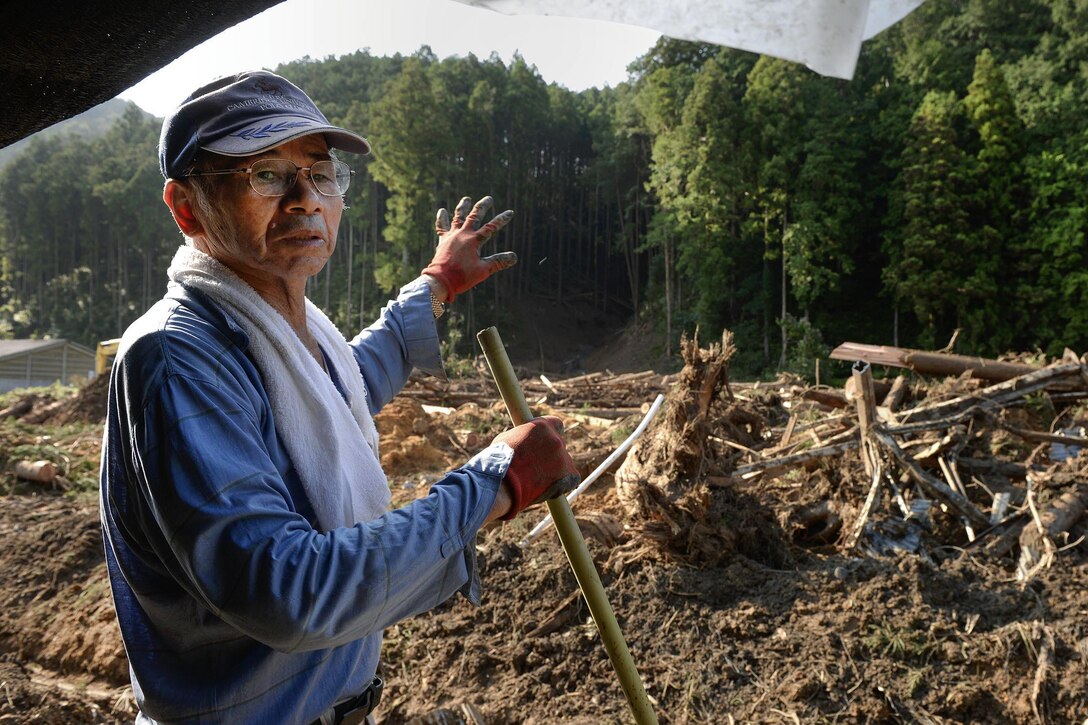 Sota Watanabe, a local farmer, explains how a landslide destroyed much of his property at Kanuma City, Tochigi prefecture, Japan, Sept. 15, 2015. U.S. Air Force photo by Staff Sgt. Cody H. Ramirez 