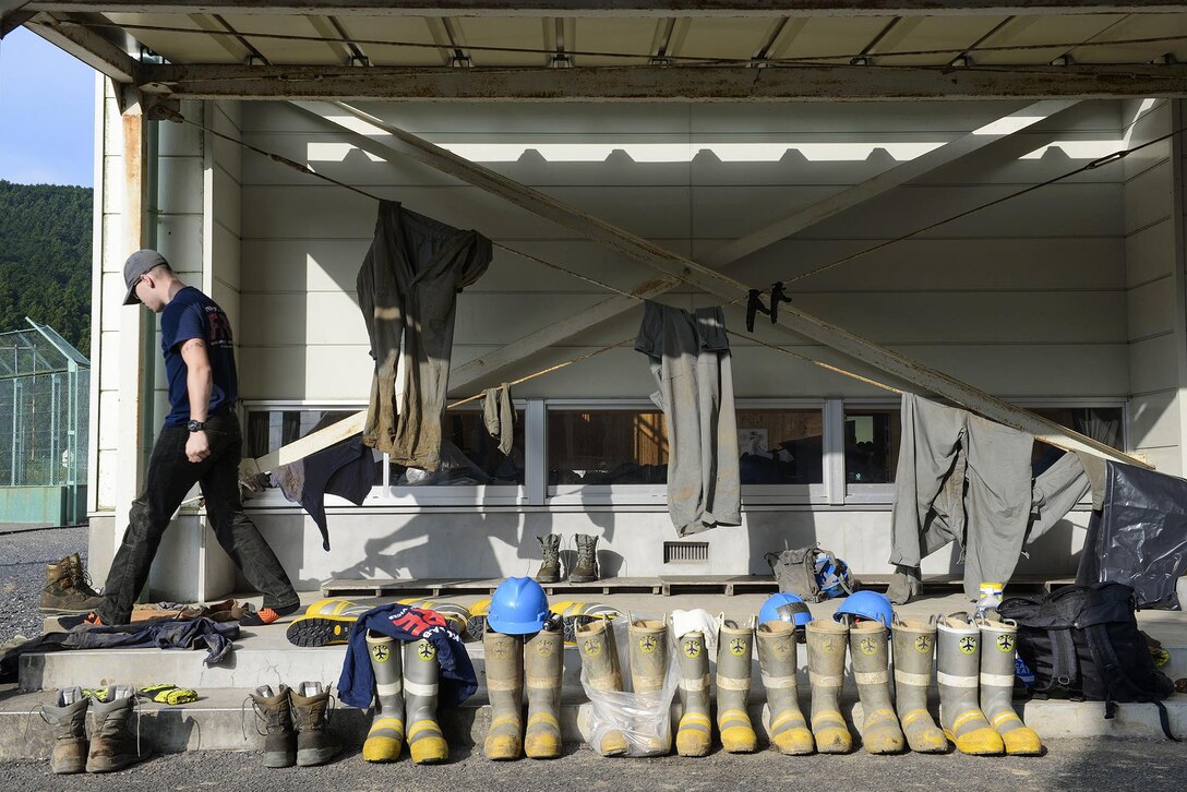 A U.S. airman searches for his boots early in the morning outside the gym of an elementary school at Kanuma City, Tochigi prefecture, Japan, Sept. 15, 2015. The airman is a fire protection member assigned to the 374th Civil Engineer. U.S. Air Force photo by Staff Sgt. Cody H. Ramirez 