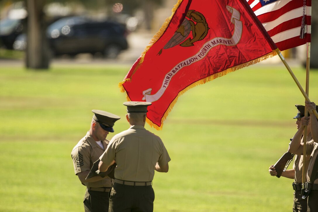 Lt. Col. Brian Middleton, commanding officer, and 1st Sgt. Robert Anderson, battalion sergeant major, 3rd Battalion, 4th Marines, 7th Marine Regiment, unfurl the battalion’s colors during the reactivation ceremony of 3/4 at Lance Cpl. Torrey L. Gray Field, Sept. 17, 2015.