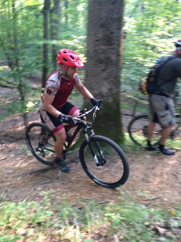 Master Sgt. John Paul Cooley, QMTB president, rides uphill on a club ride on base.