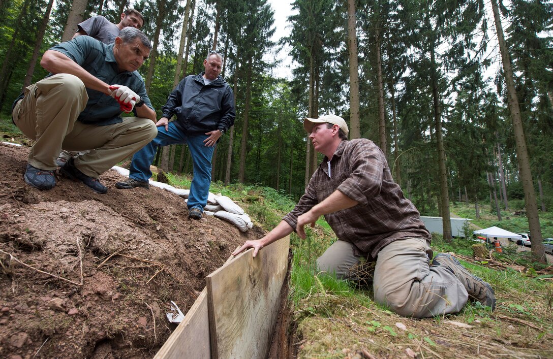 Robert Ingraham, right, a forensic archaeologist and recovery leader with the Defense POW/MIA Accounting Agency, explains a soil profile to retired Army Lt. Gen. Michael S. Linnington, left, director of the Defense POW/MIA Accounting Agency, and other agency leaders during a recovery mission located near Riechelsdorf, Germany, Sept. 1, 2015. DoD photo by U.S. Air Force Staff Sgt. Brian Kimball