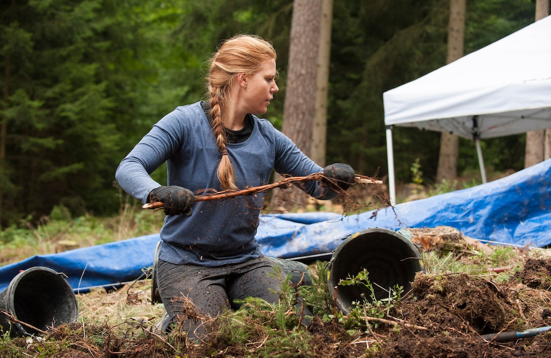 U.S. Army Cpt. Irene Zoesch clears dirt from a root at a Defense POW/MIA Accounting Agency excavation site during a recovery mission located near Riechelsdorf, Germany, Sept. 1, 2015. Zoesch is a medical doctor assigned to the Carl R. Darnall Army Medical Center. DoD photo by U.S. Air Force Staff Sgt. Brian Kimball