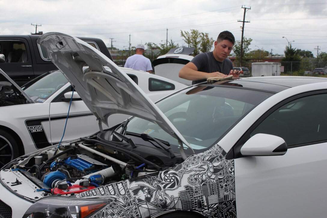 Sgt. Daniel Musgrove, OCS, wipes down his Scion TC. Musgrove designed and drew the custom artwork on the car using a Sharpie. “I did it free-hand, and it took about 11 hours,” he said. The designs feature auto parts, airplanes, a turbo snail, and the skyline of his hometown, Pittsburgh.