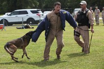 Micheal McGarr participates in a K-9 training demonstration at Marine Corps Air Station Cherry Point, N.C., Sept. 18, 2015. The demonstration was a part of a series of activities available for spouses and families to partake in, for the 2nd annual Open House event hosted by Marine Air Control Squadron 2. The event was designed to emphasize the importance of family readiness by allowing the family members to visit the work space and become familiar with the equipment that their Marines use on a day-to-day basis.  Garr is the chief trainer of the K-9 unit, with Headquarters and Headquarters squadron at MCAS Cherry Point. 