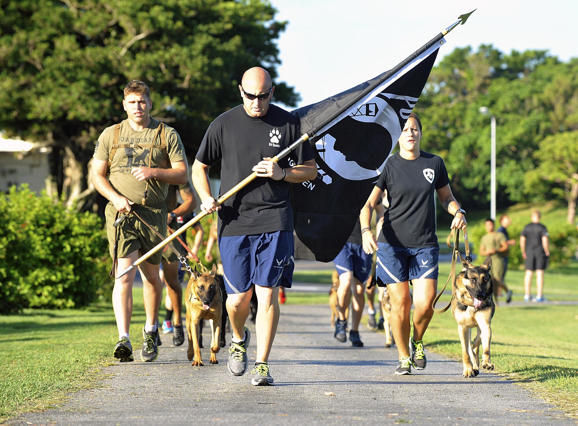 U.S. Air Force Staff Sgt. Robert Evilsizer, 18th Security Forces Squadron military working dog handler, leads the military working dog team for the first lap of the run at Marek Park Sept. 17, 2015, on Kadena Air Base, Japan. The run recognizes the sacrifices and contributions made by all veterans who have served our nation. Various groups and squadrons throughout the 18th Wing signed up for a designated time slot to run during the event in support of more than 70,000 personnel who were prisoner of war or missing in action. (U.S. Air Force photo by Naoto Anazawa/Released)