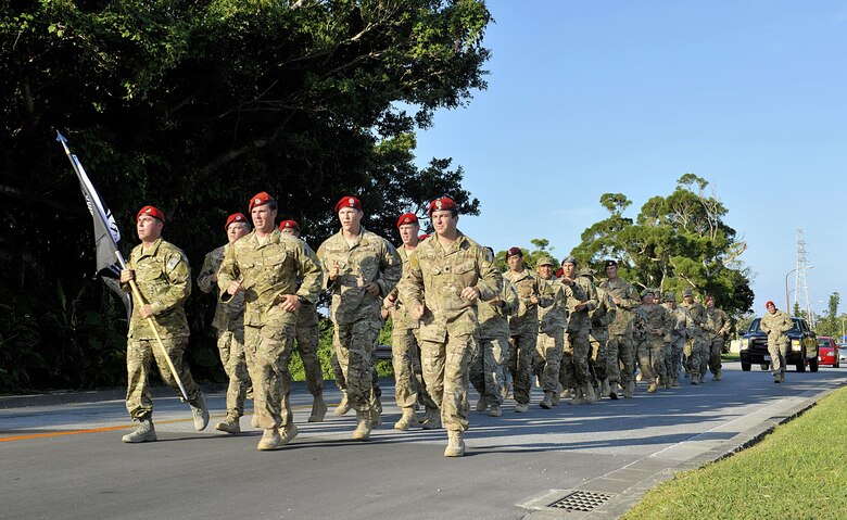 Airmen from the 320th Special Tactics Squadron carry a POW/MIA flag from a 24-hour vigil run at the Marek Park track to a POW/MIA recognition breakfast held at the Officers' Club Sept. 18, 2015, on Kadena Air Base, Japan. Team Kadena honored service members who were prisoners of war or missing in action with a 24-hour vigil run. The run recognizes the sacrifices and contributions made by all veterans who have served our nation. (U.S. Air Force photo by Naoto Anazawa/Released)