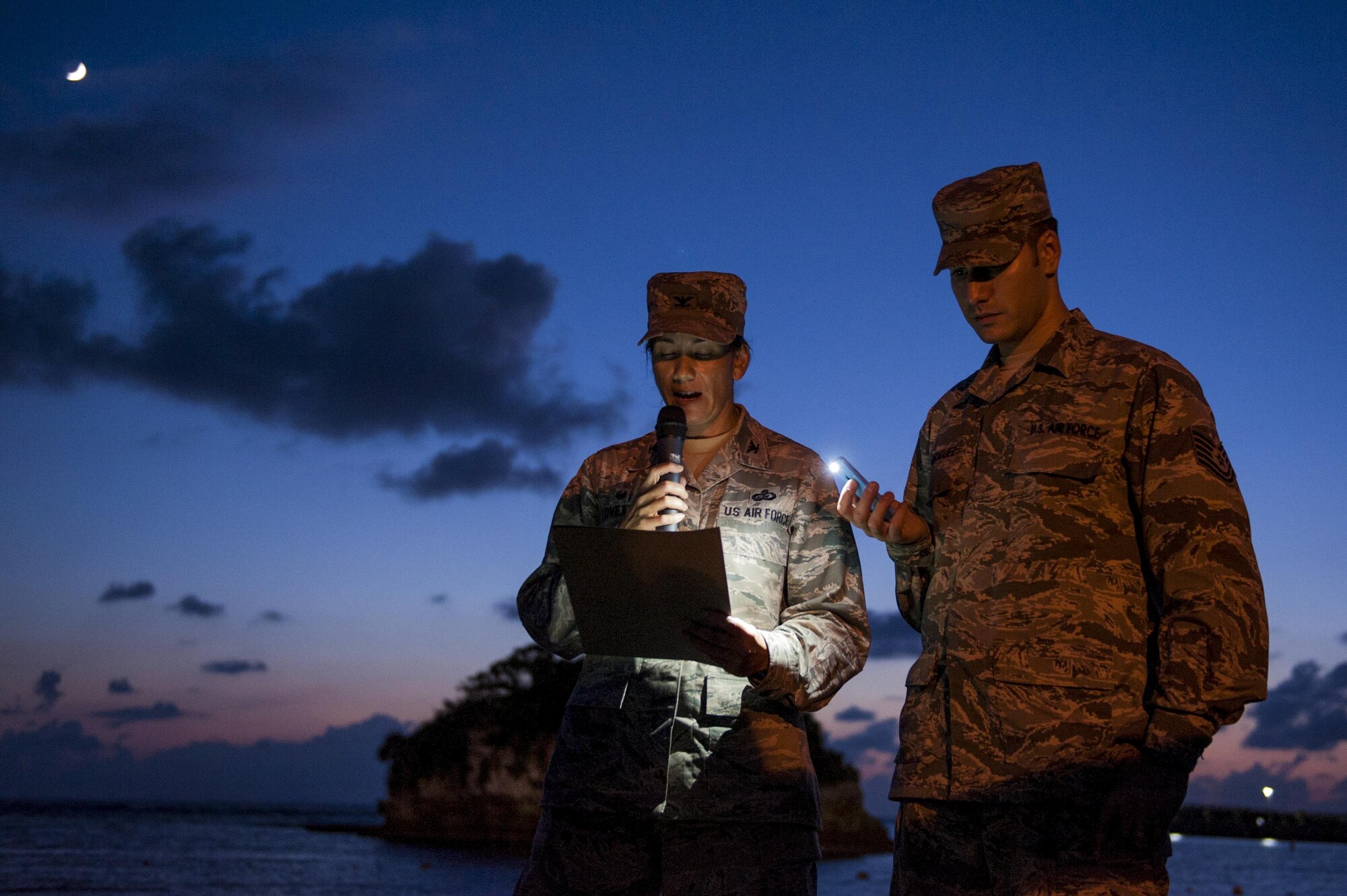 U.S. Air Force Col. Debra Lovette, 18th Mission Support Group commander, speaks while Tech. Sgt. Ezequiel Rodriguez, 18th Operations Support Squadron NCO in charge of airfield management, holds a light for her during the POW/MIA Sky Lantern Ceremony Sept. 17, 2015, at the Kadena Marina, Kadena Air Base, Japan. The sky lantern ceremony was held to honor POWs and MIAs. This particular ceremony was the first of its kind for Kadena. (U.S. Air Force photo by Airman 1st Class Lynette M. Rolen/Released)