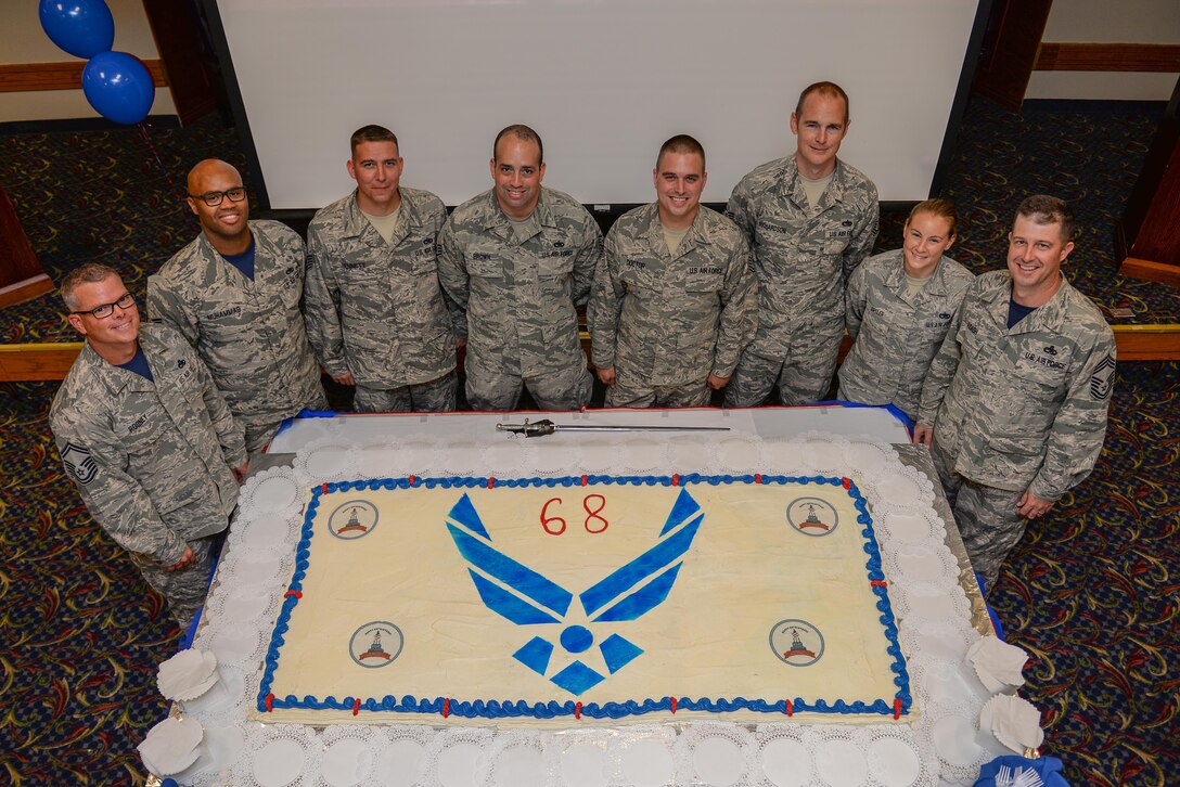 Airmen stand in front of a cake at the Sheppard Club, Sheppard Air Force Base, Texas, during the Air Force’s 68th birthday celebration, Sept. 18, 2015. The Air Force birthday is celebrated each year to reflect on the service and sacrifices of its ancestors. (U.S. Air Force photo/Senior Airman Kyle Gese)