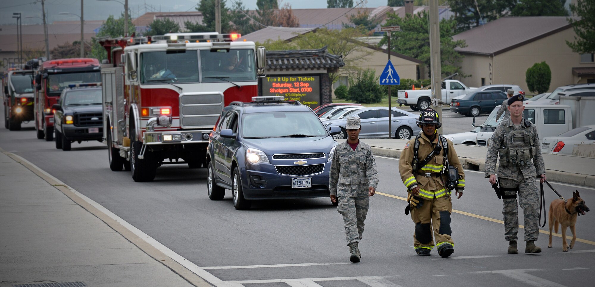 An Air Force medic, firefighter and security forces patrolman with his military working dog lead a silent movement to the 9/11 remembrance ceremony site Sept. 11, 2015, at Osan Air Base, Republic of Korea. Fourteen years separates us from the destruction that shook America. Exactly 2,977 innocent lives were taken that fateful day on Sept. 11, 2001. (U.S. Air Force photo/Tech. Sgt. Travis Edwards)
