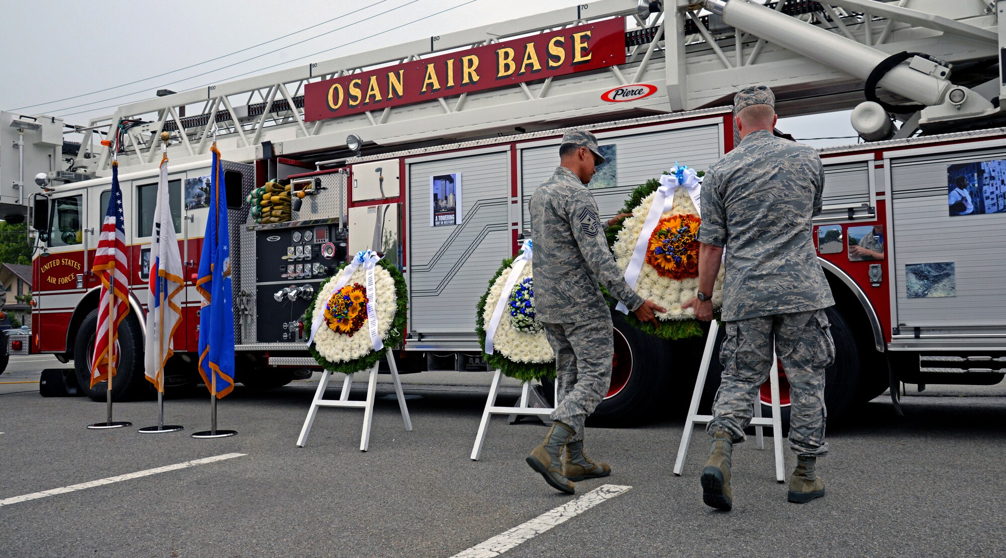 Chief Master Sgt. Terrance Greene, 51st Fighter Wing command chief, and Col. Brian Carr, 51st FW vice commander, lay the third and final wreath during the 9/11 remembrance ceremony Sept. 11, 2015, at Osan Air Base, Republic of Korea. Osan Airmen paid tribute to the 2,977 innocent lives that were taken Sept. 11, 2001, by climbing 110 flights of stairs, making a silent movement to the ceremony site and concluded with a wreath-laying ceremony.  (U.S. Air Force photo/Tech. Sgt. Travis Edwards)
