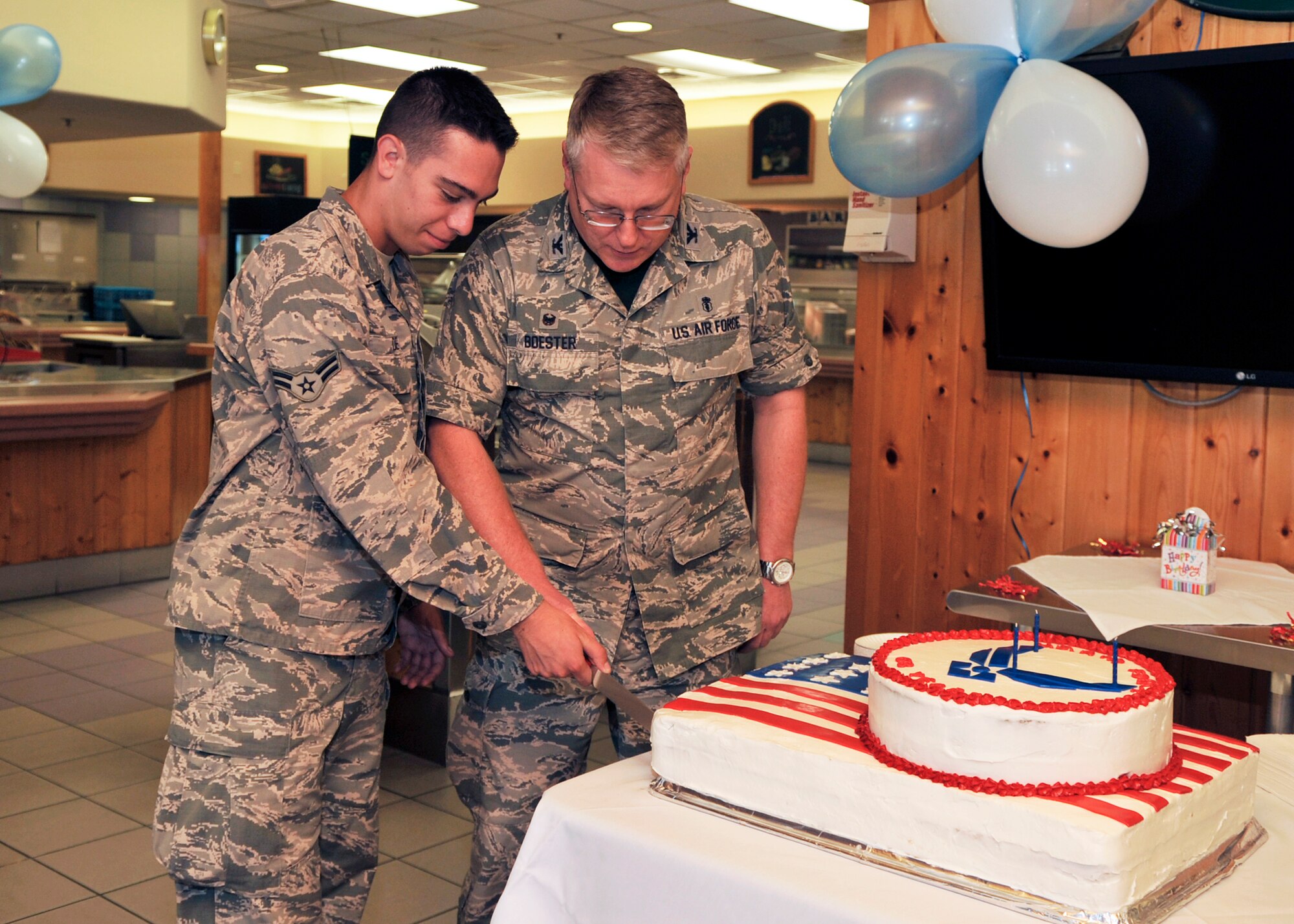Col. Russell Boester, 56th Dental Squadron deputy commander, and Airman First Class Michael De Ubl, 56th Aircraft Maintenance Squadron F-35 armament specialist, cut a cake September 18, 2015 at Luke Air Force Base, Arizona. The cake cutting ceremony was performed to celebrate the 68th Birthday of the U.S.  Air Force. (U.S. Air Force photo by Staff Sgt. Marcy Copeland)  