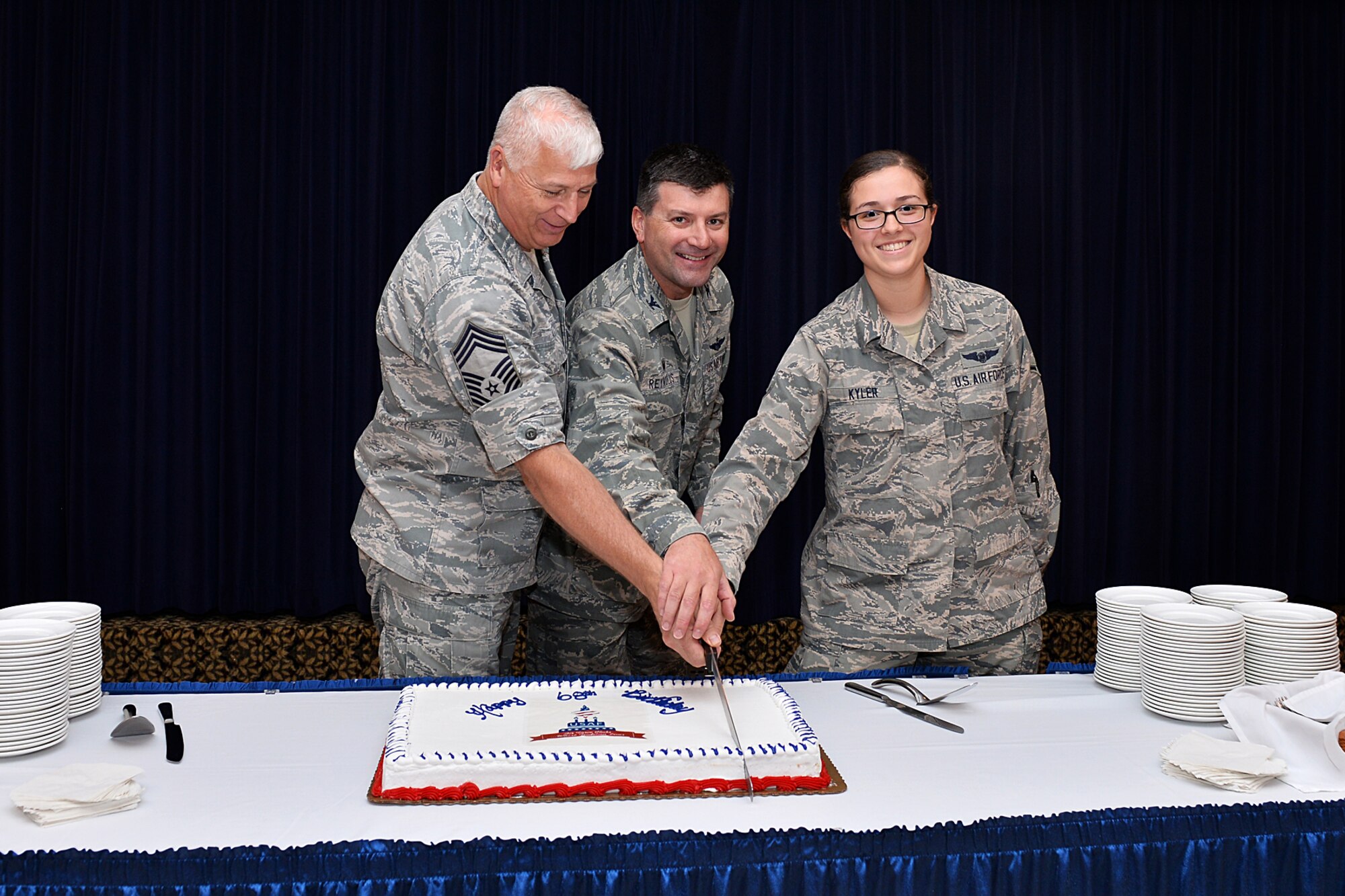 U.S. Air Force Chief Master Sgt. Robert Wege, 55th Maintenance Group, U.S. Air Force Col. Marty Reynolds, 55th Wing commander, and U.S. Air Force Airman Ashley Kyler, 338th Combat Training Squadron, cuts the ceremonial cake during the U.S. Air Force 68th Birthday celebration inside the Patriot Club, Offutt Air Force Base, Neb., Sept. 17. Chief Master Sgt. Robert Wege was the oldest Airman in attendance and Airman Ashley Kyler was the youngest. 
