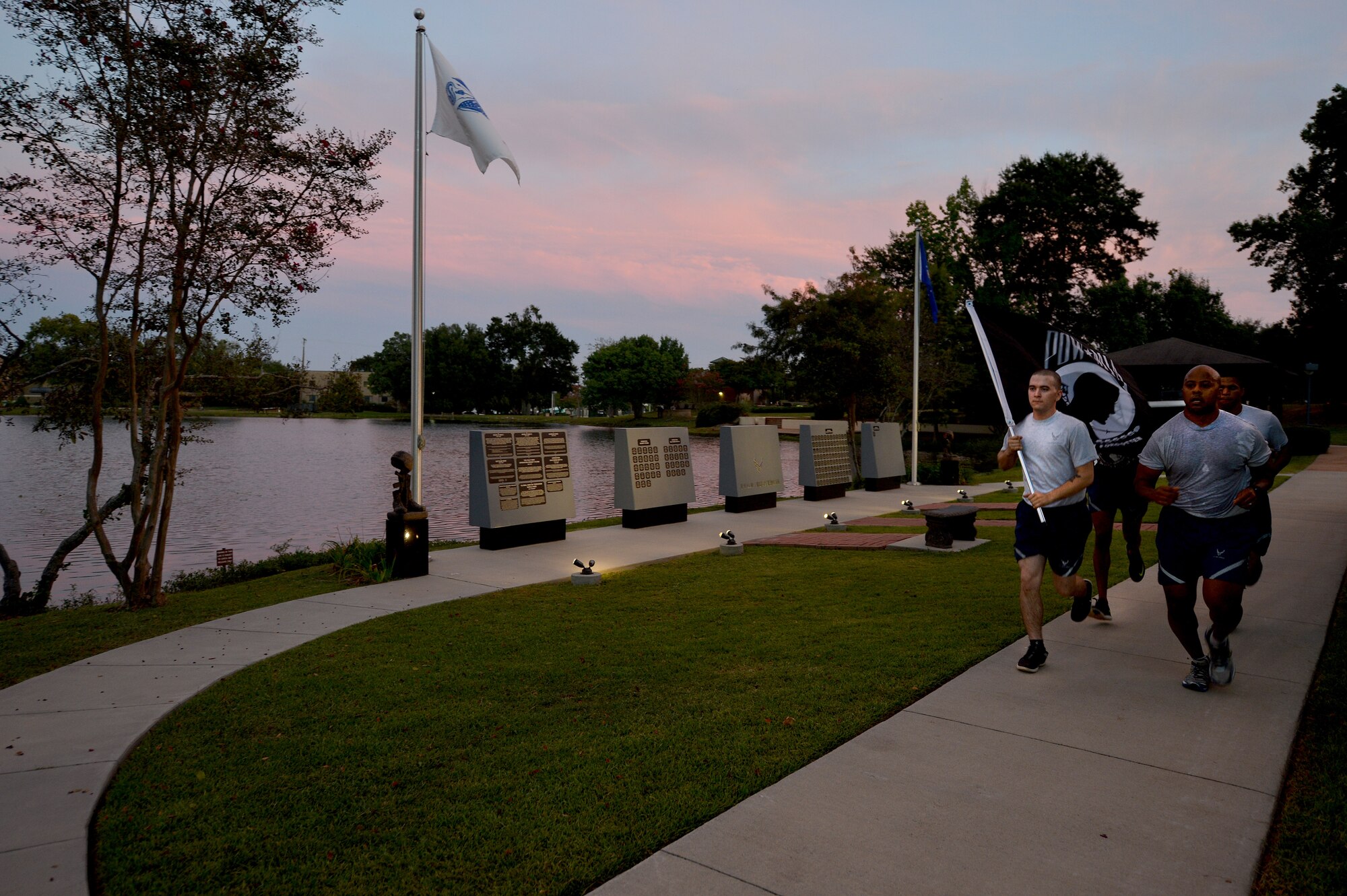 U.S. Air Force Airmen run with the POW/MIA flag during the 24-hour POW/MIA Recognition Day vigil run at Shaw Air Force Base, S.C., Sept. 17, 2015. Participants took turns for an hour running with the flag, ensuring it never stopped until the 24 hours were completed. (U.S. Air Force photo by Senior Airman Diana M. Cossaboom/Released)