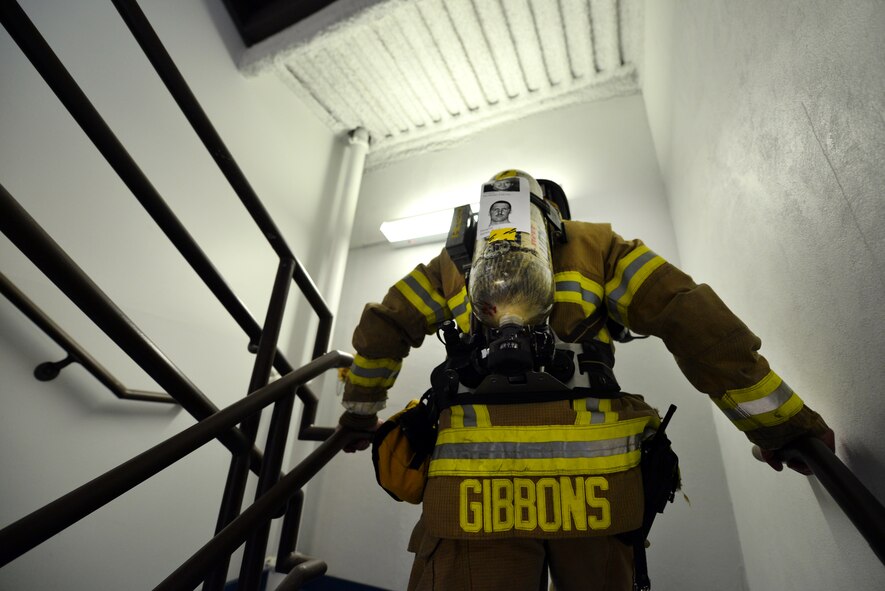 Mathew Gibbons, a fireman at Offutt Air Force Base, Neb. climbs the stairs of the Offutt flight tower 13 times with names and faces of the fallen New York City firemen taped to his oxygen tank on Sept. 11.   The 9/11 tribute attracted dozens of emergency response professionals from around the base.  (U.S. Air Force photo by Josh Plueger/Released)