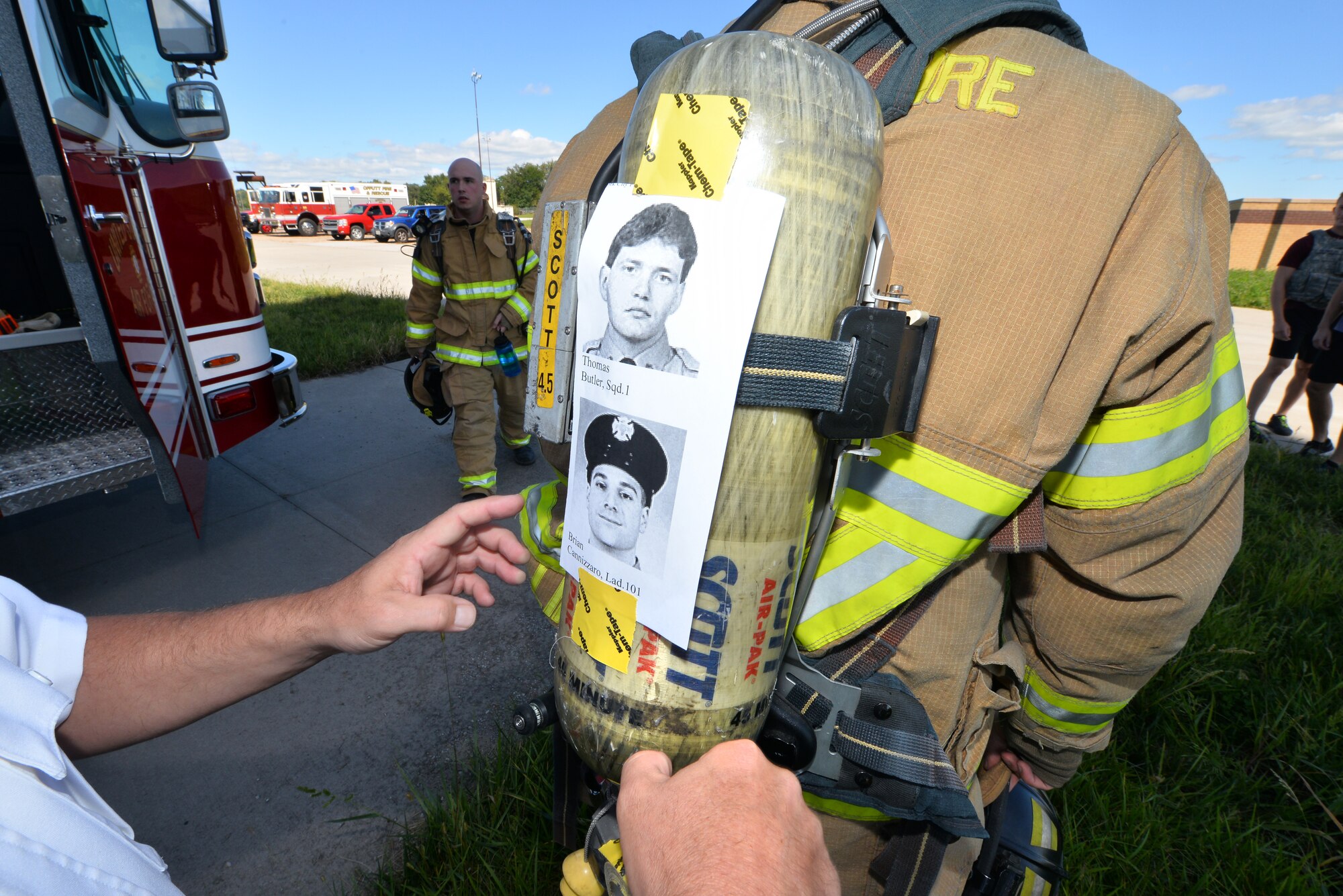 The names and faces of the fallen New York City Fireman are taped to the oxygen tanks of Offutt Air Force Base firemen prior to a Flight Tower run on Sept. 11, Offutt Air Force Base, Neb.  The Offutt fireman would scale the Flight Tower 13 times to mimic the amount of stairs scaled in the Twin Towers.  (U.S. Air Force photo by Josh Plueger/Released)