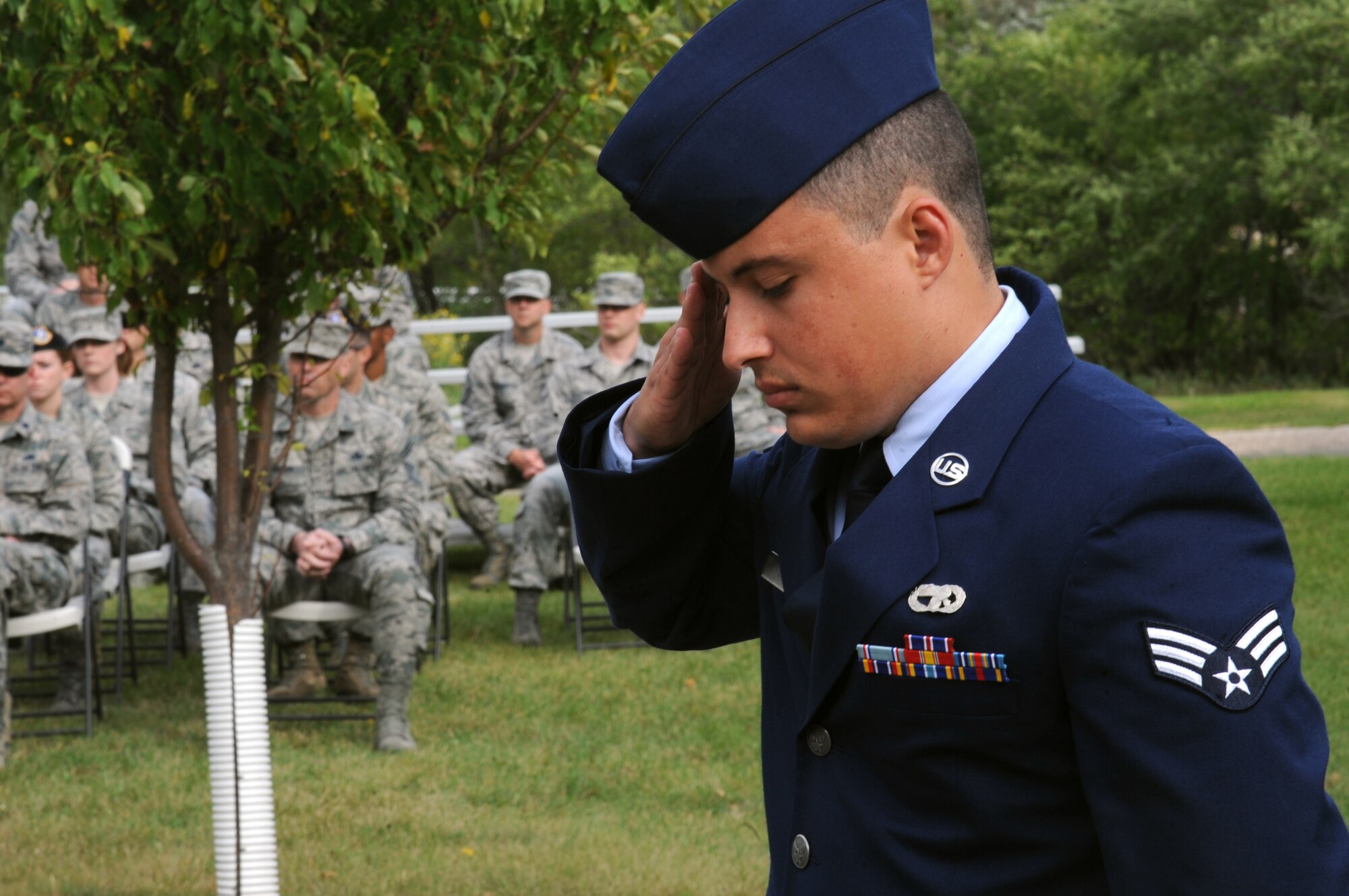 Senior Airman Brandon Misita, 319th Logistics Readiness Squadron traffic management journeyman, renders a salute during a POW/MIA ceremony at Grand Forks Air Force Base, North Dakota, Sept. 17, 2015. During the ceremony, a brief description of each member located at the Freedom Tree Memorial was read aloud followed by a salute. (U.S. Air Force photo by Senior Airman Desiree Economides/Released)