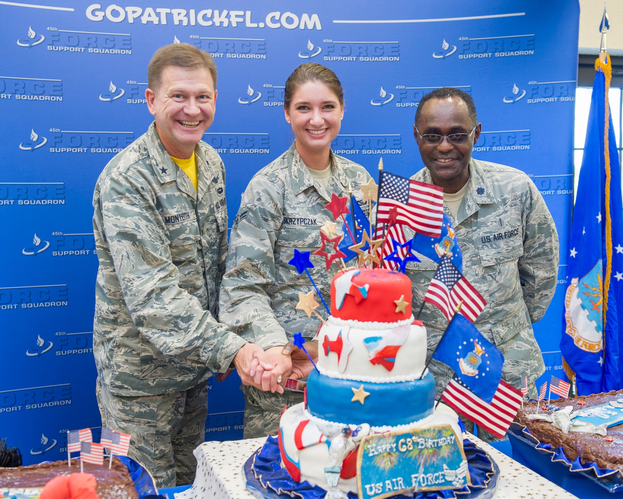 Brig. Gen. Wayne Monteith, 45th Space Wing commander, Airman 1St Class Katie Skrzypczak, 45th Civil Engineer Squadron, youngest Airman, and Lt. Col. Leonid Katkovsky, 45th Aerospace Medical Squadron, oldest Airman, in keeping with the tradition of cutting the Air Force Birthday cake during a celebration at the Patrick Air Force Base Golf Course and Marina, Sept. 18, 2015. (U.S. Air Force photo/Matthew Jurgens/Released) 