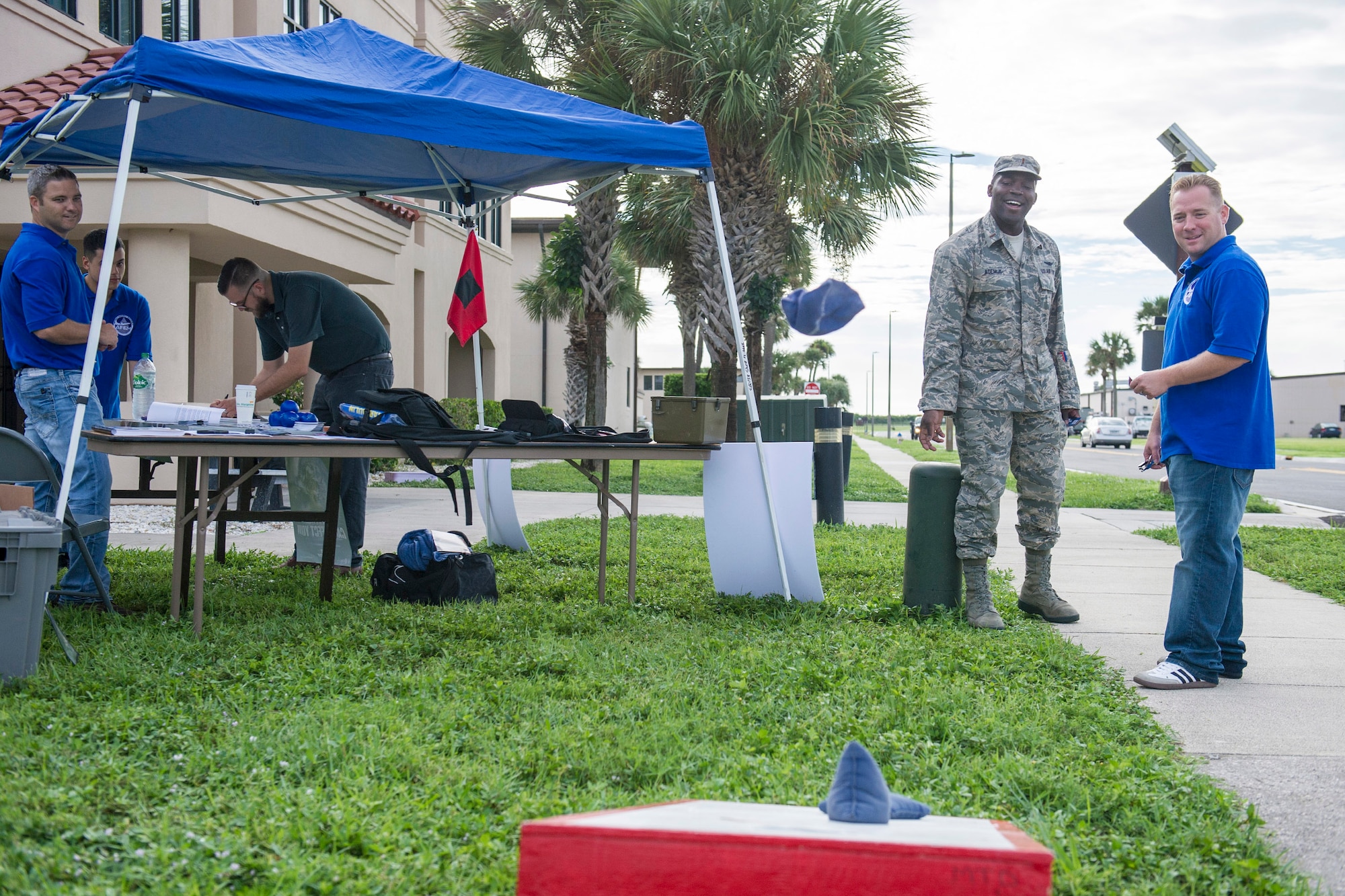 Second Lt. Moshood Adeniji, 1st Range Operations Squadron, left, plays Cornhole in front of the fitness center Sept. 18, 2015, at Patrick Air Force Base, Florida, as Tech. Sgt. Aaron Burnley, 45th Civil Engineer Squadron emergency manager, assists him. September is National Preparedness Month, and team Patrick-Cape promoted the emergency planning month with a booth outside of the fitness center. (U.S. Air Force photo by Matthew Jurgens/Released)