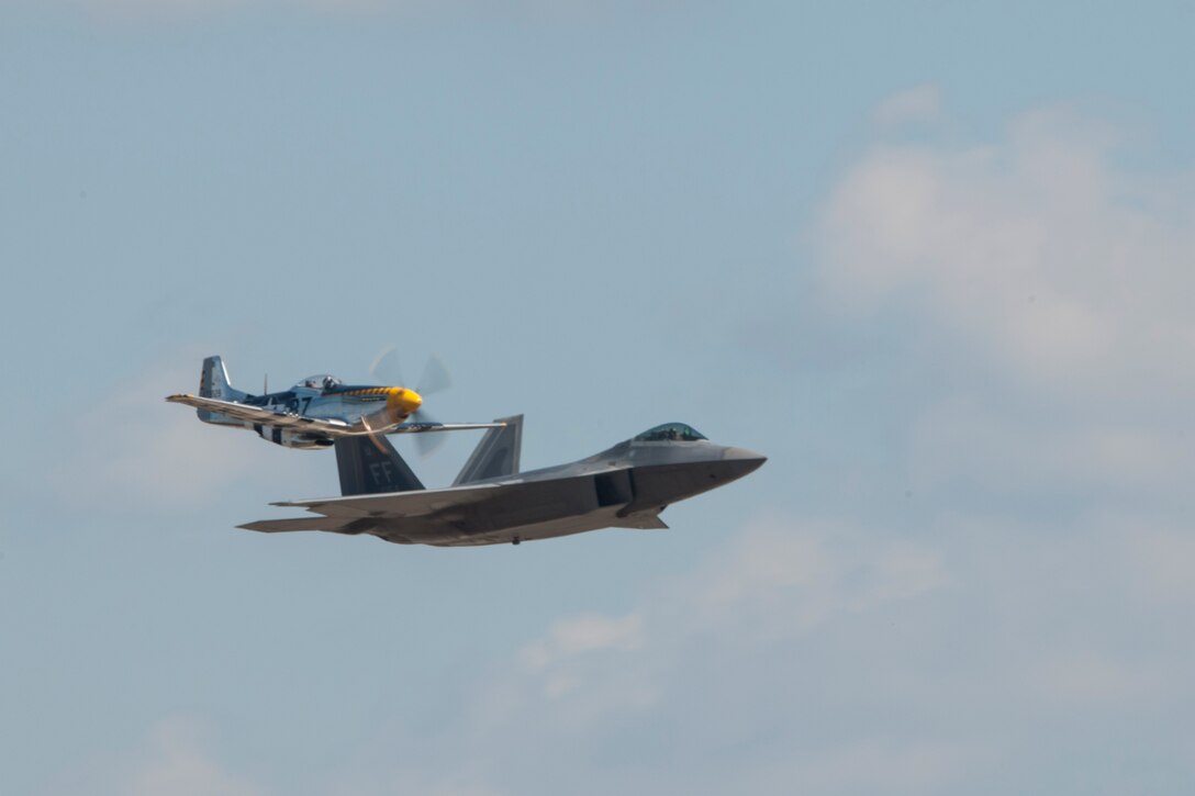 P-51 Mustang and a U.S. Air Force F-22 Raptor fighter aircraft perform during an air show rehearsal Sept. 18, 2015 at Joint Base Andrews, Md. The P-51 and F-22 will participate in the 2015 JBA Air Show, Sept.19, 2015. (U.S. Air Force photo by Senior Airman Dylan Nuckolls/Released)