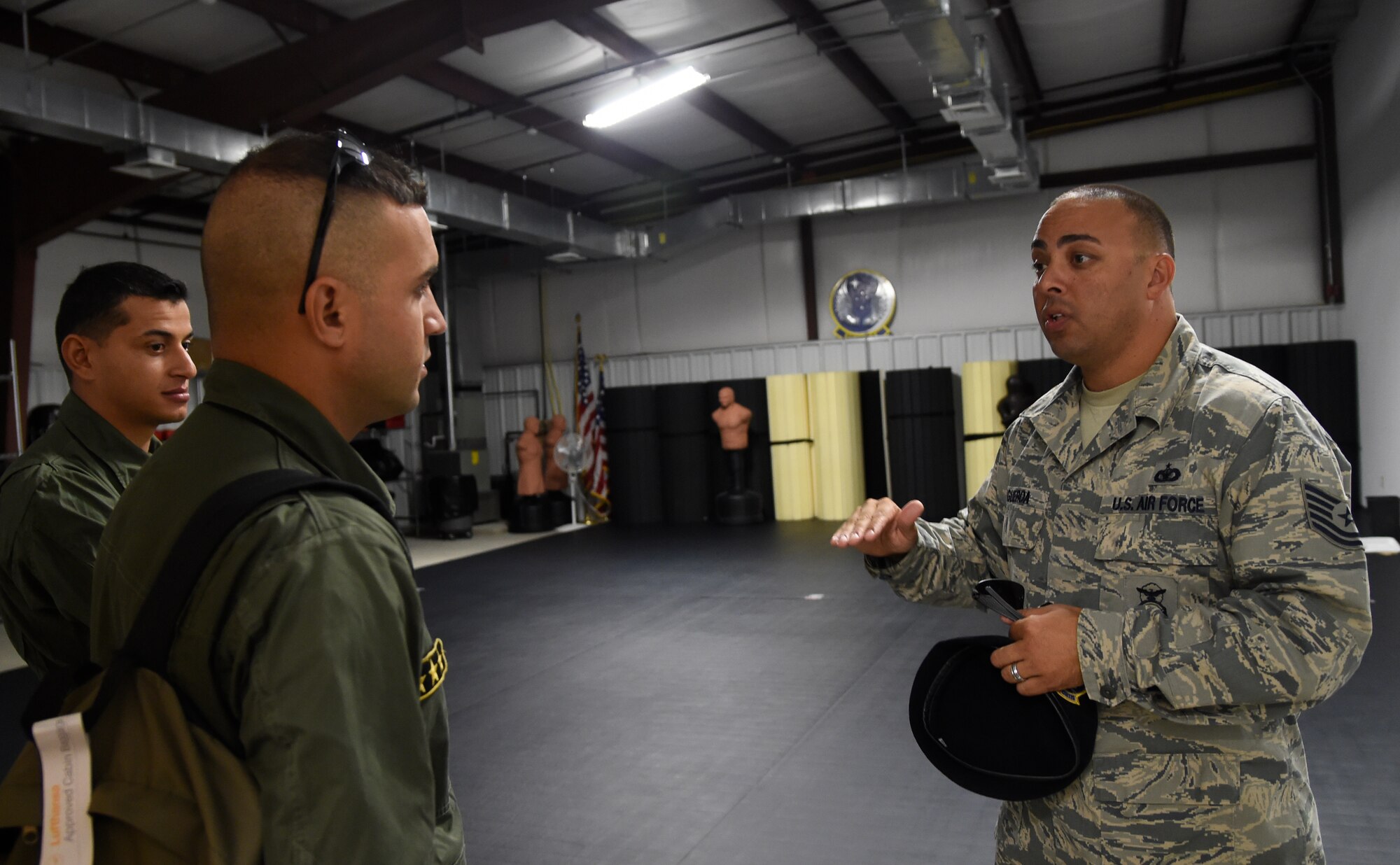 Tech. Sgt. Julio Figueroa, 818th Mobility Support Advisory Squadron air advisor, speaks to two Tunisian Airmen about the MSAS combatives program during their visit at Joint Base McGuire-Dix-Lakehurst, N.J., Sept. 15, 2015. The weeklong engagement focused on sharing ideas and experiences in the realm of airbase defense. (U.S. Air Force photo by Staff Sgt. Gustavo Gonzalez)