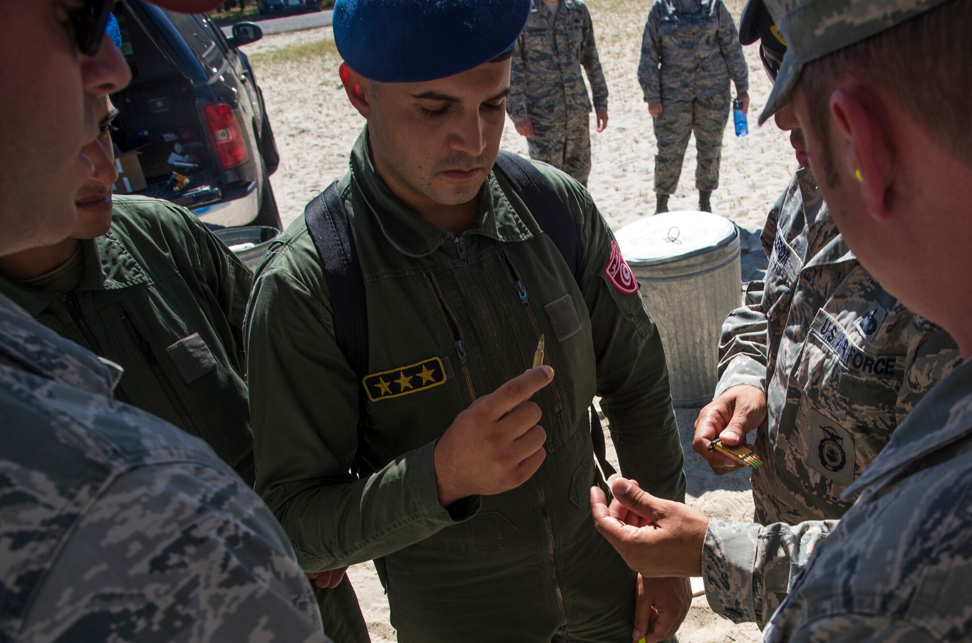 Tunisian Air Force Capt. Mrizak Ezzeddine speaks with defenders assigned to the 621st Contingency Response Wing regarding ammo during their visit to the firing range during their tour hosted by the CRW's 818th Mobility Support Advisory Squadron at Joint Base McGuire-Dix-Lakehurst, N.J., Sept. 15, 2016. The weeklong engagement focused on sharing ideas and experiences in the realm of airbase defense. Engaging with partner nations in air mobility operations helps increase the capacity to move to locations where partner nations are interested in improving humanitarian assistance/disaster relief, regional stability and peacekeeping operations. (U.S. Air Force photo by Staff Sgt. Gustavo Gonzalez)
