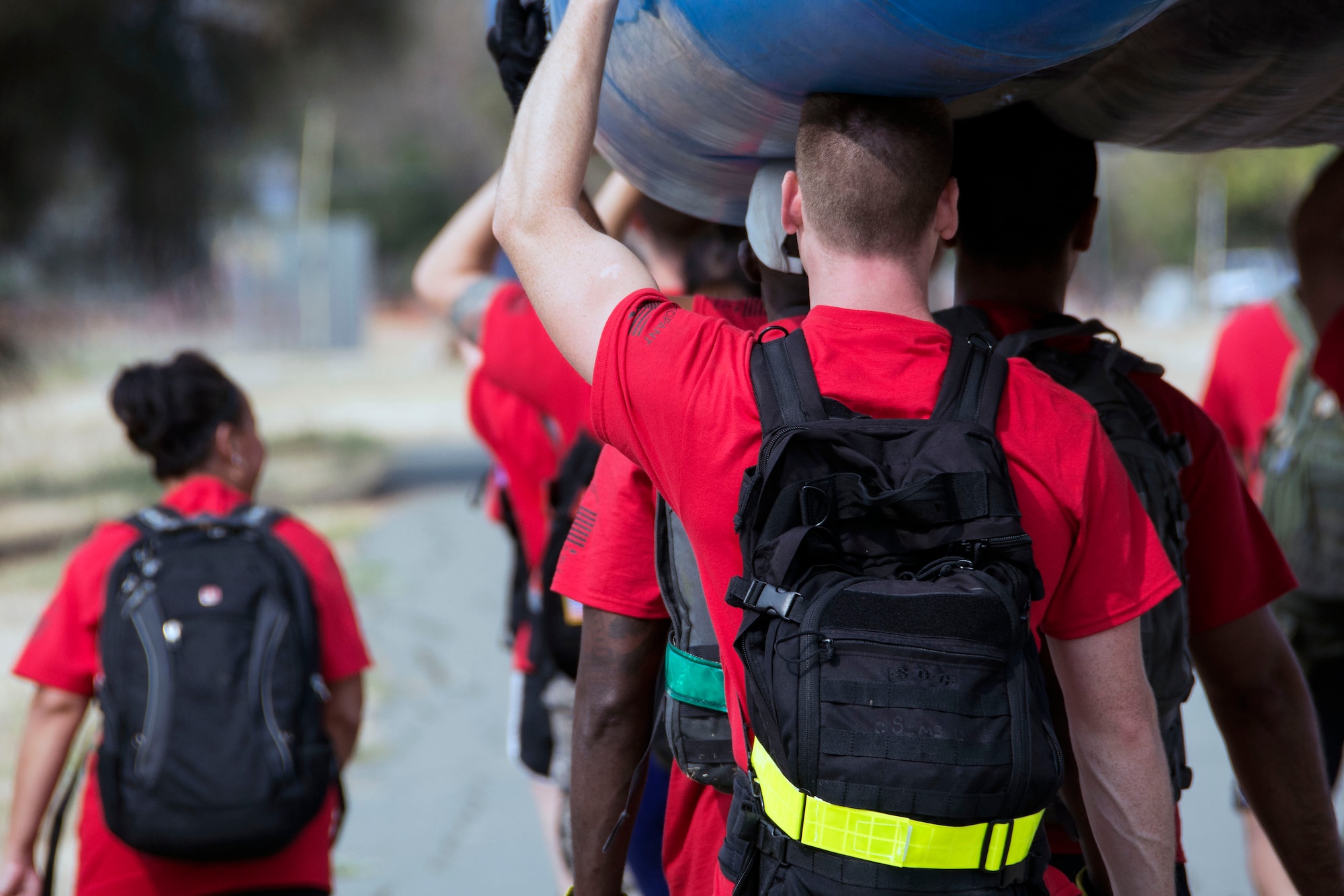 Sixteen GoRuck Light Challenge participants overhead carry a river raft Sept. 12, 2015, at Travis Air Force Base, California. For nearly six hours participants dragged tractor-sized tires, overhead carried river rafts, completed rigorous body-weight based exercises and rucked more seven miles. (U.S. Air Force photo/Senior Airman Charles Rivezzo)