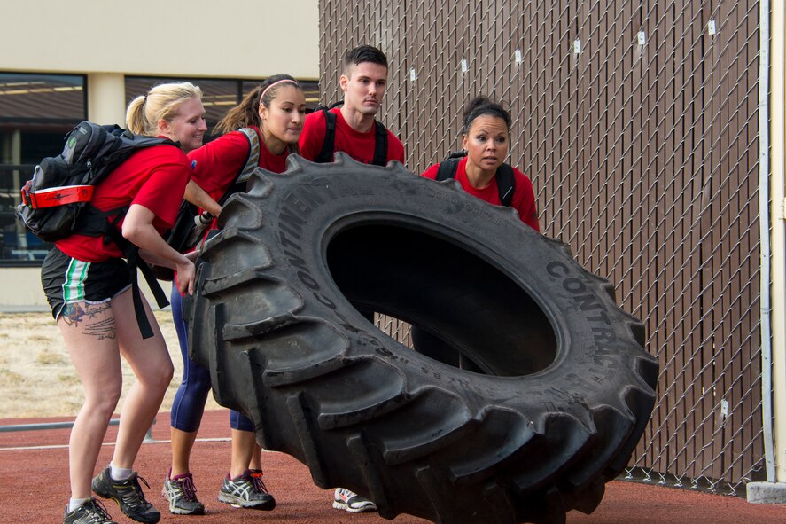 GoRuck Light Challenge participants flip a tractor-sized tire Sept. 12, 2015, at Travis Air Force Base, California. For nearly six hours participants dragged tractor-sized tires, overhead carried river rafts, completed rigorous body-weight based exercises and rucked more seven miles. (U.S. Air Force photo/Senior Airman Charles Rivezzo)