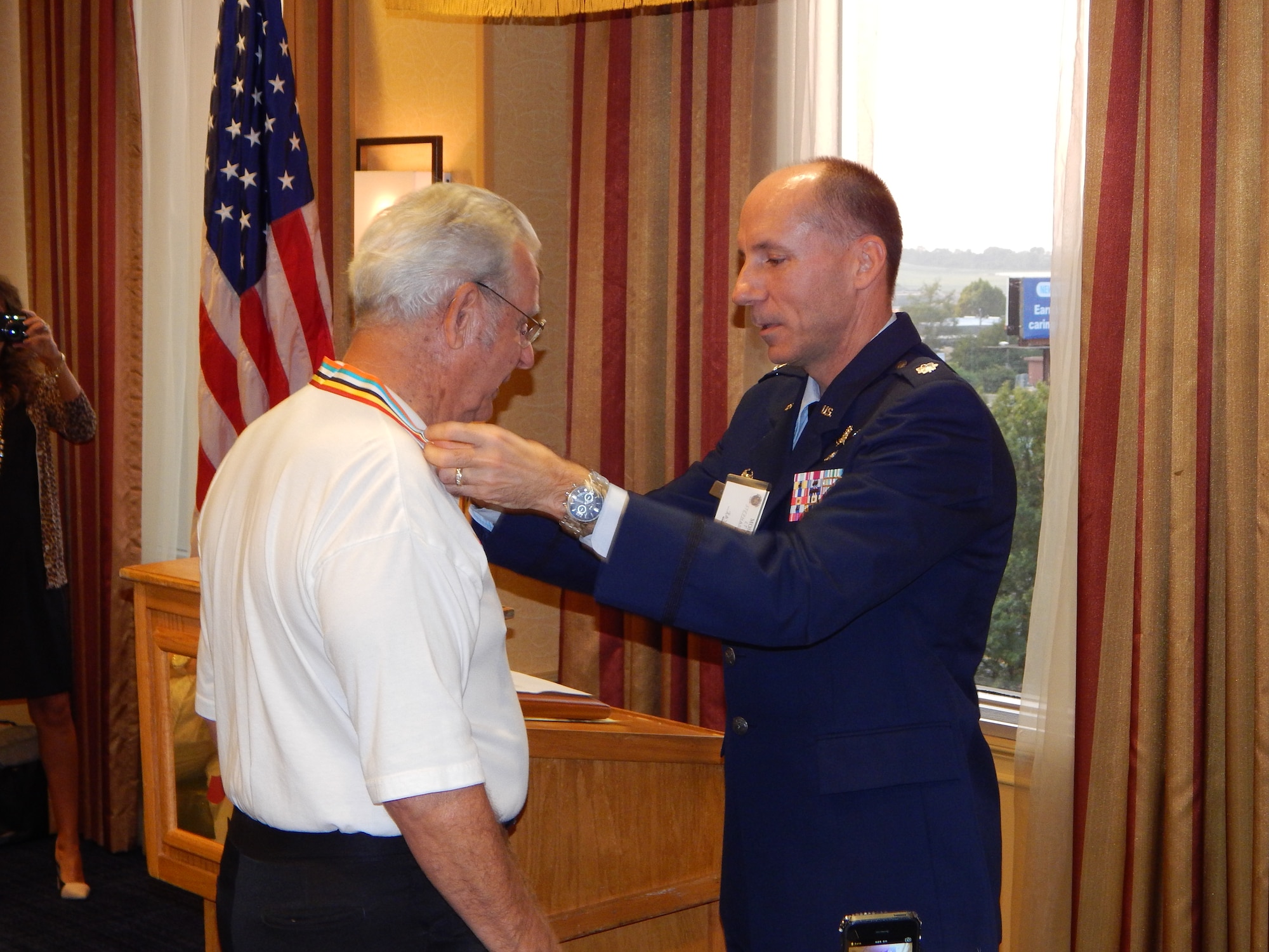 Lt Col Stephen Esposito, commander, 375th Communications Support Squadron, presents the Korean Ambassador for Peace Medal to John Dichard who is the youngest Mosquito at 78.  He retired from the Air Force as a master sergeant with 20 years, four months and three days of service. (U.S. Air Force photo/Christine Spargur)