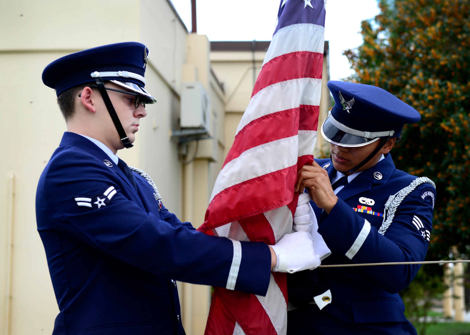 U.S. Air Force Airman 1st Class Roger Lanoie and Senior Airman Juanita Stewart, 31st Fighter Wing Honor Guard members, remove the Prisoner of War/Missing in Action flag during the remembrance week’s retreat ceremony Sept. 17, 2015, at Aviano Air Base, Italy. The Air Force Sergeants Association hosted several events during the week, including a vigil run and table ceremony to remember fellow service members. (U.S. Air Force photo by Senior Airman Areca T. Bell/Released)