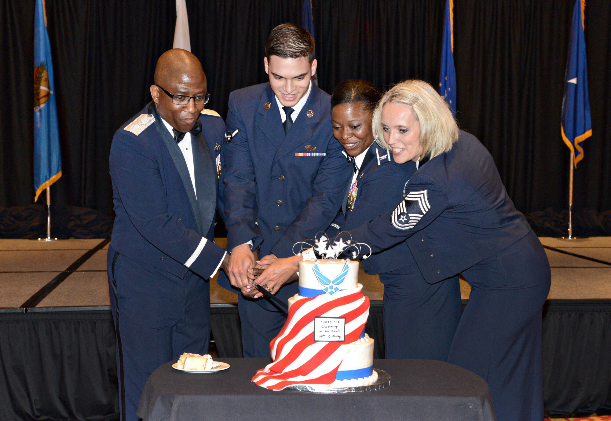 Cutting the ceremonial cake at the Sept. 12 Air Force Ball are, from left, Brig. Gen. Allen Jamerson, director of Security Forces and deputy chief of staff for Logistics, Engineering and Force Protection  at Headquarters U.S. Air Force; Airman Luis Nieves Gonzalez, 552nd Operations Support Squadron; Col. Stephanie Wilson, 72nd Air Base Wing commander; and Chief Master Sgt. Larae Chapman, 72nd Medical Group. The cake is traditionally cut by the highest ranking or presiding official and the youngest service member in attendance. (Air Force photo by Kelly White/Released)