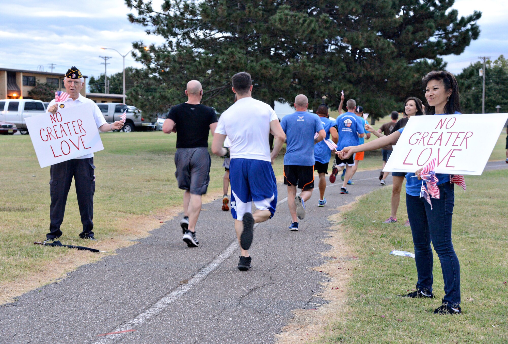 VFW member Nelson Ryan and Janina Peters, from the Tinker Chapel, encourage participants and hand out American flags during the Sept. 11 event. Many of the participants halted their run to thank Mr. Nelson for his past service to the country. (Air Force photo by Kelly White/Released)