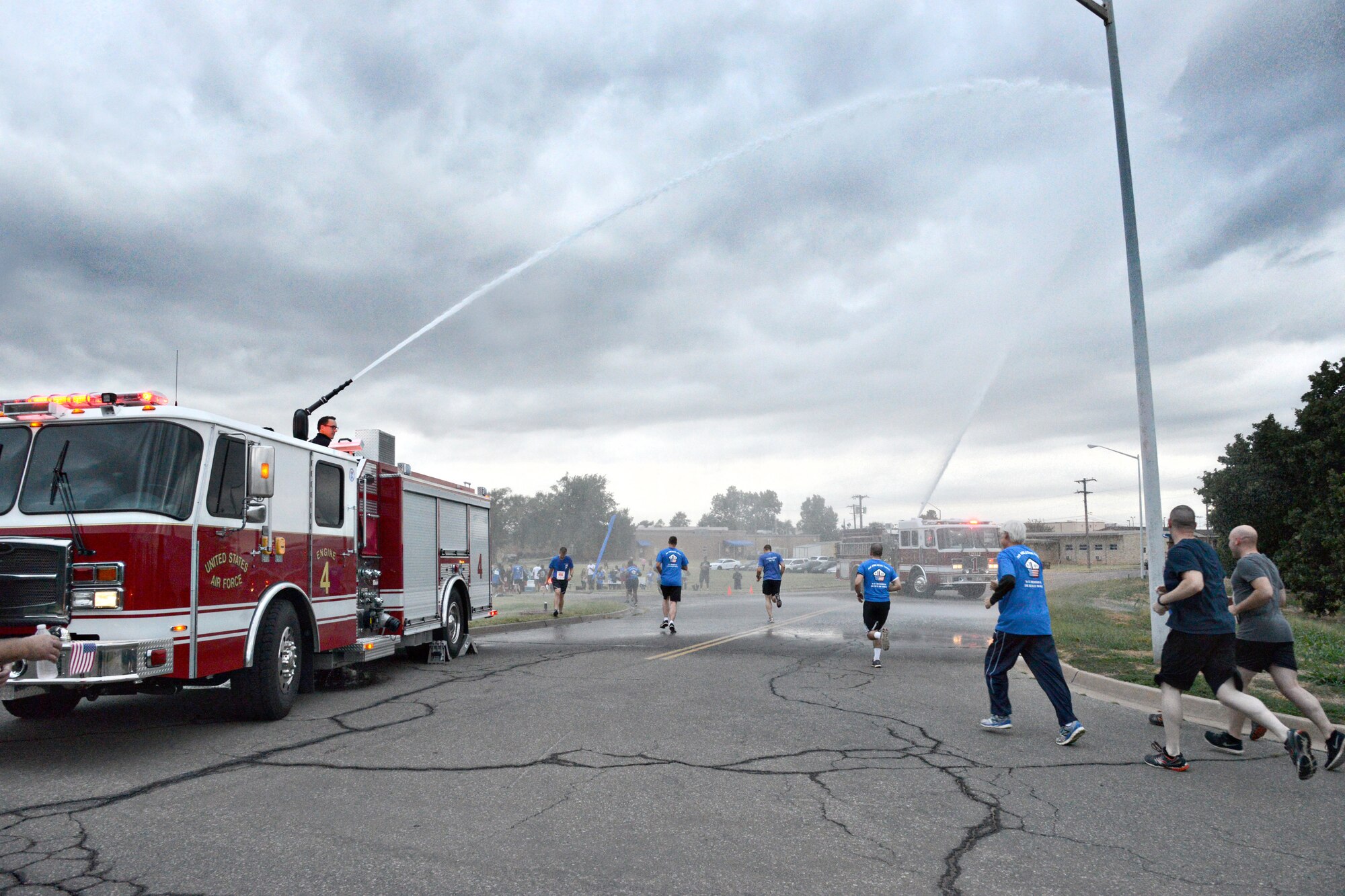 The Tinker Fire and Emergency Services surprised runners with two high streams of water from their fire trucks during the Sept. 11 No Greater Love/9-11 Memorial 5K run/2K walk. Several firefighters dressed in full gear to honor their fallen brothers by running in the event. (Air Force photo by Kelly White/Released)