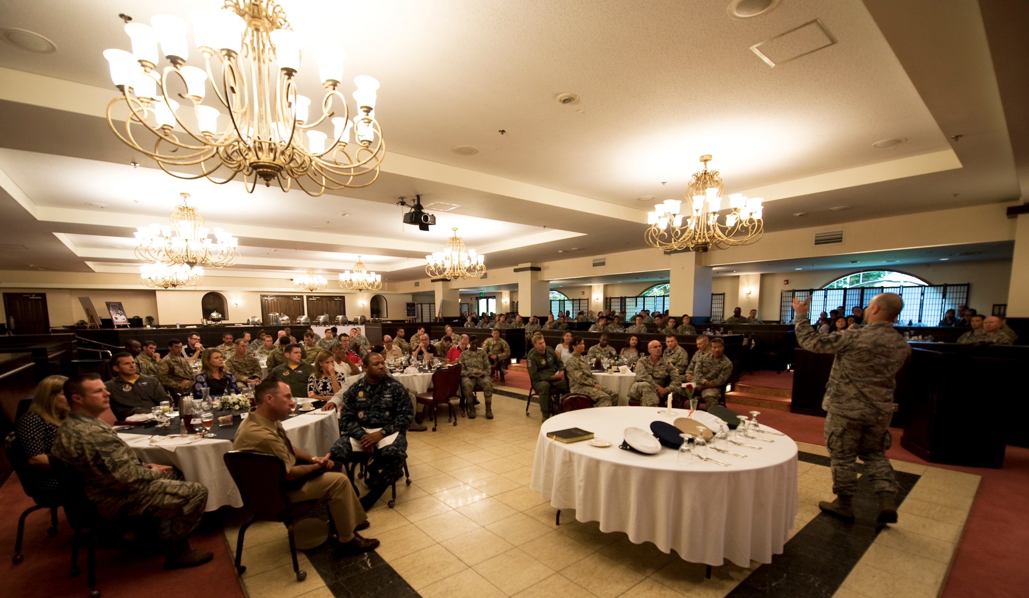 Service members listen to guest speaker Senior Master Sgt. Caleb Ethridge, 31st Rescue Squadron superintendent, during a Prisoner of War/Missing in Action breakfast at the Kadena Officer’s Club Sept. 18, 2015, Kadena Air Base, Japan. The breakfast was held in remembrance of service members who were prisoners of war or never made it home. (US Air Force photo by Airman 1st Class Nicholas Emerick)
