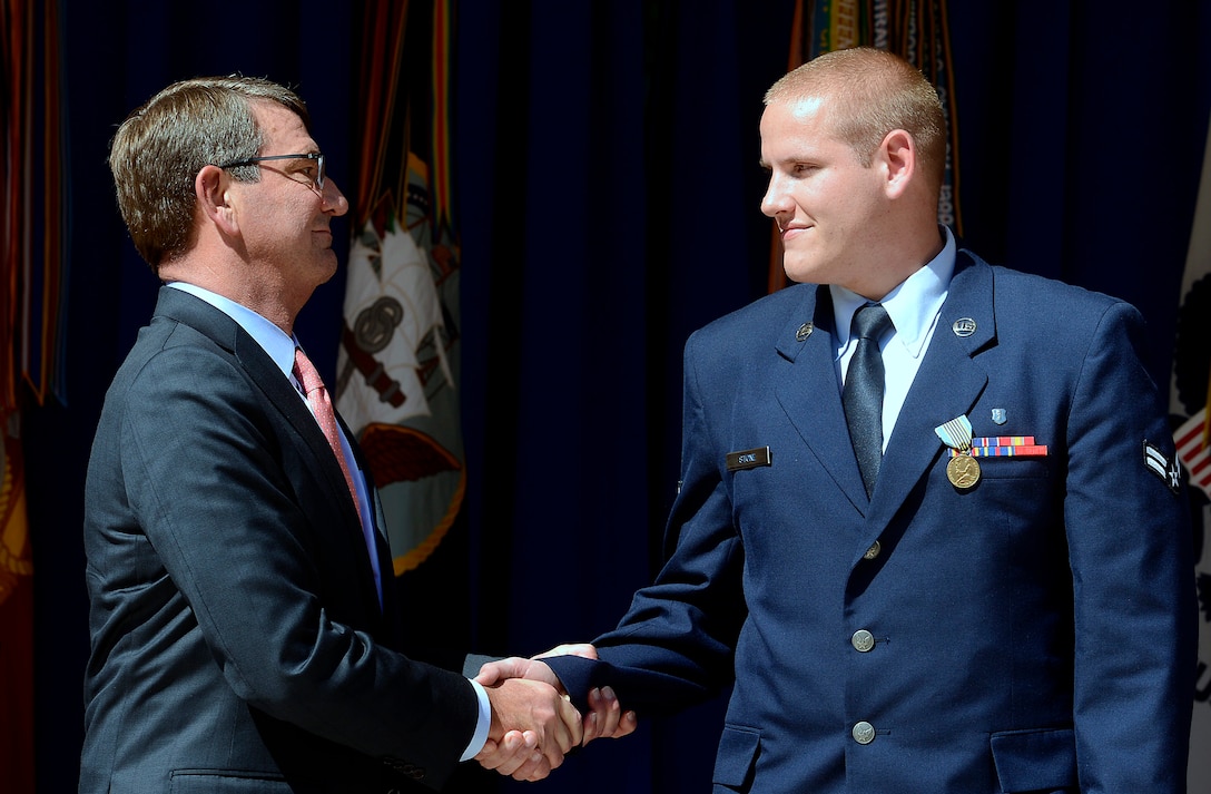 Defense Secretary Ash Carter shakes hands with Airman 1st Class Spencer Stone after presenting him the Airman’s Medal at the Heroes of the Rails ceremony at the Pentagon, Sept. 17, 2015. Stone received the Airman’s Medal and the Purple Heart for bravery and valor for his heroic actions to thwart a gunman’s attack on a French train in Paris in August 2015. Air Force photo by Scott Ash