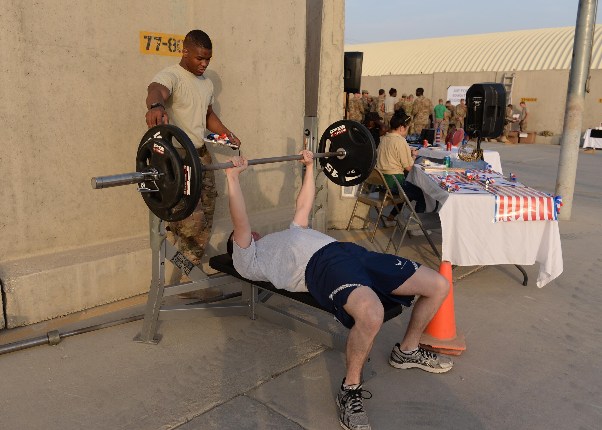 U.S. Air Force Senior Airman Kionne Lewis, 455th Expeditionary Logistics Readiness Squadron cargo movement specialist, spots an Airman during a bench press challenge at the Air Force birthday celebration Sept. 18, 2015, at Bagram Airfield, Afghanistan. The block party which was hosted by the Armed Forces Committed to Excellence council, the 455th Force Support Squadron and other private organizations featured games, food and a traditional AF cake cutting ceremony. (U.S. Air Force photo by Senior Airman Cierra Presentado/Released)