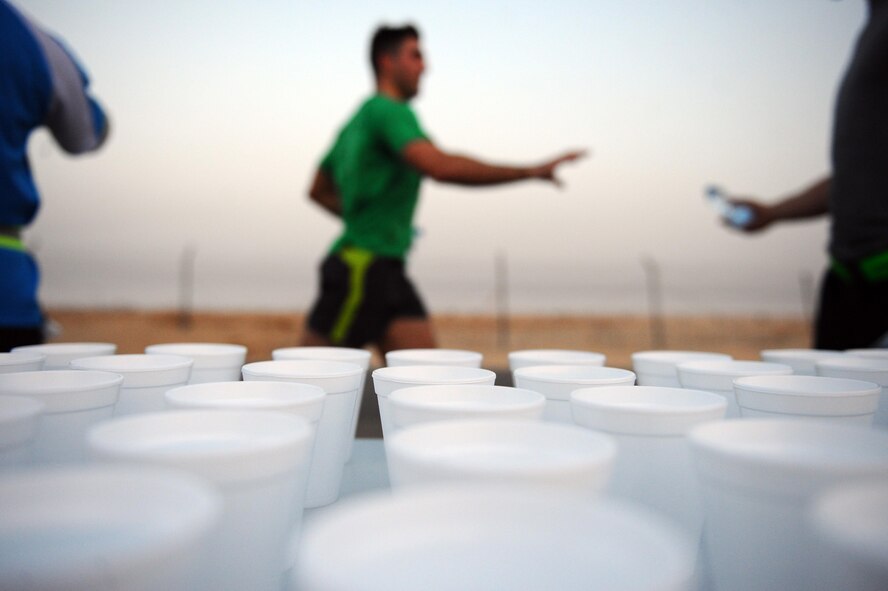 Volunteers offer runners water during the Air Force Half Marathon at a deployed location in Southwest Asia, Sept. 19, 2015. Members deployed in support of Operation Inherent Resolve started the race at 5 a.m., with temperatures already in the mid-90s. (U.S. Air Force photo/Tech Sgt. Brittany E. Jones)