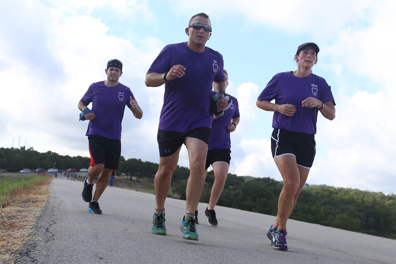 Tyler Goehring, Senior Master Sgt. Daniel Stellabotte, 381st Training Squadron dental lab career development course writer,  and Maj. Sarah Wheeler, 359th Medical Group dentist, run on top of Canyon Lake dam during the Rambler 120 Sept. 19, 2015, at Joint Base San Antonio Recreation Park at Canyon Lake. The Rambler 120, which is hosted by the 502nd force Support Squadron, features four- and eight person teams that engage in a friendly, but third-fought, competition that challenges participants with a 22-mile bike race, 6-mile raft race and a mystery event. (U.S. Air Force photo by Senior Airman Alexandria Slade/Released)