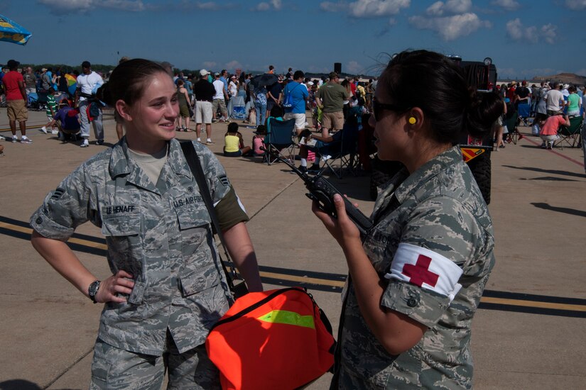 Senior Airman Mika Le Henaff, 779th Medical Group aerospace medical technician, and Staff Sgt. Misty Chaar, 779th Dental Squadron oral surgery technician, discuss medical protocol on the flightline on Join Base Andrews, Md., Sept. 19, 2015. The 779th MDG provided medical support for the 2015 Joint Base Andrews Air Show. (U.S. Air Force photo by Senior Airman Dylan Nuckolls/Released)